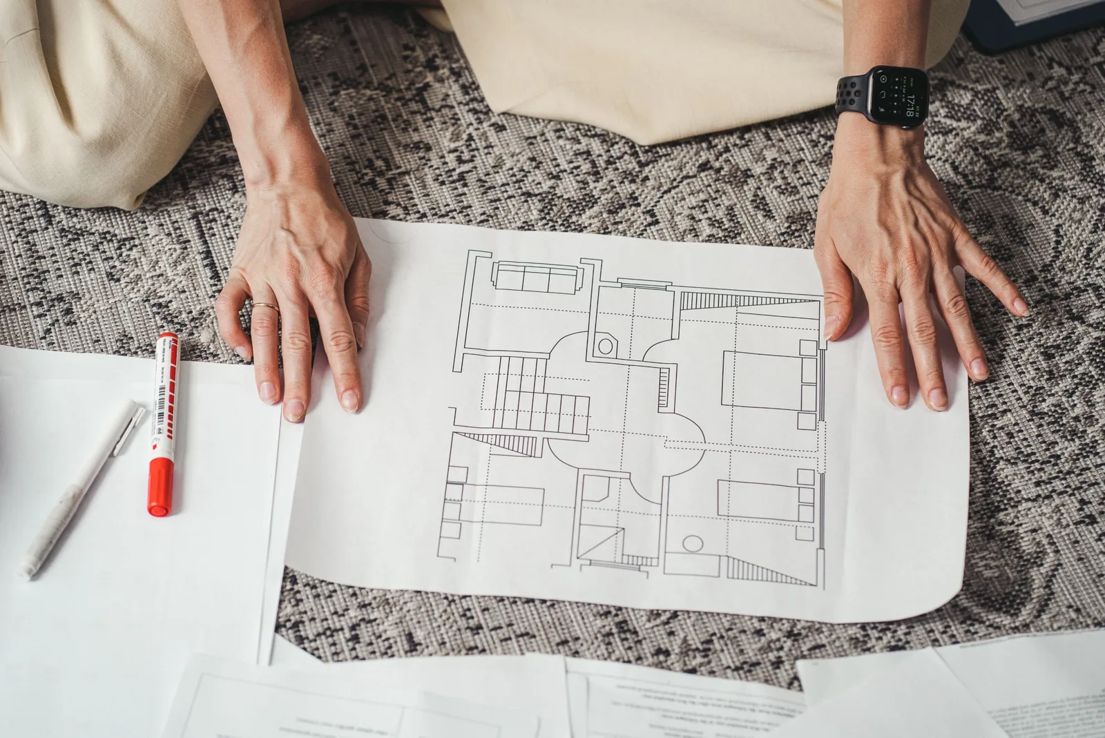 Plan cadastral et formulaire d'urbanisme sur une table, terrain délimité au crayon avec maison dessinée