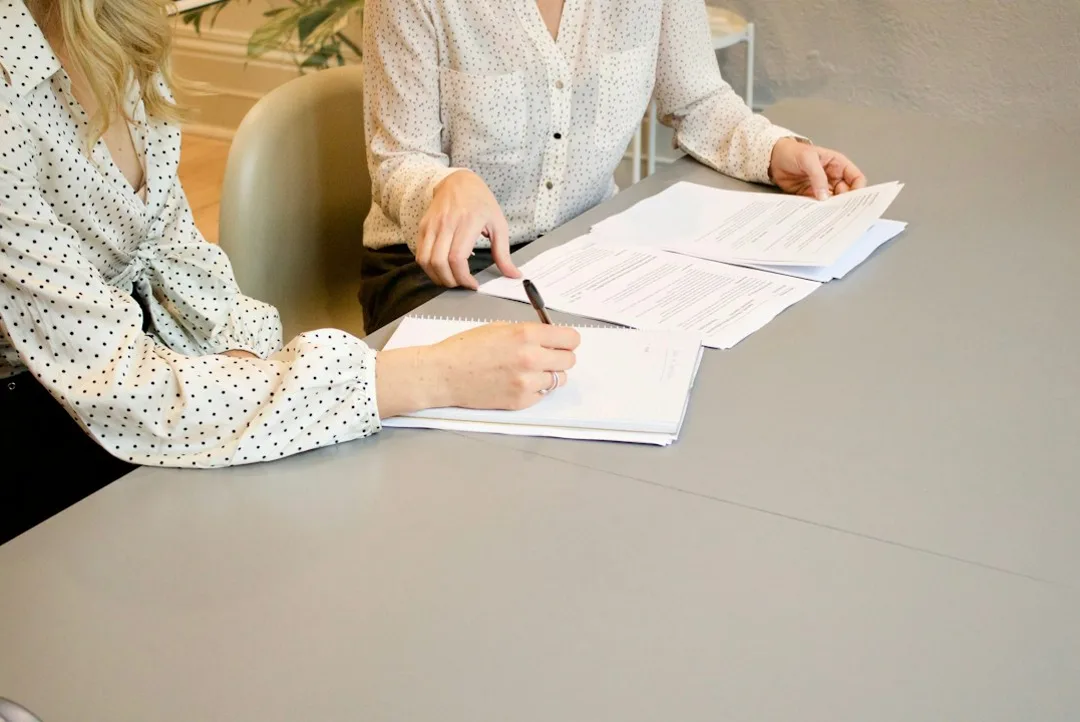 Bureau associatif réuni autour de statuts imprimés, discutant de la gouvernance et du budget de l'association
